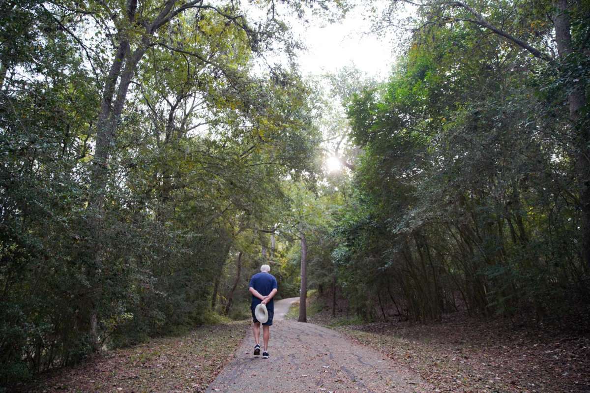 A pedestrian walks on the Terry Hershey trail in Houston on Oct. 26, 2021. The signs of the trail recently changed from speed limits for cyclists to more inclusive signage on trail etiquette.