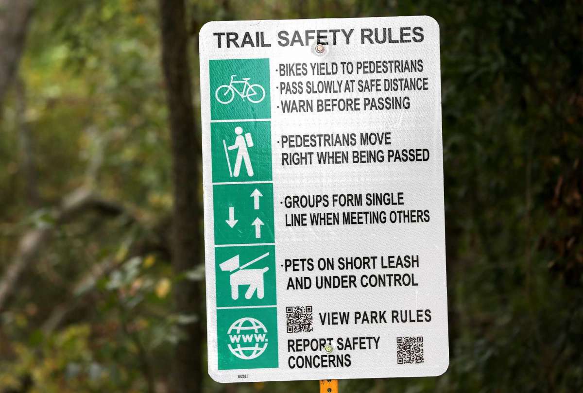 New signs at the Terry Hershey trail in Houston on Oct. 26, 2021. The signs of the trail recently changed from speed limits for cyclists to more inclusive signage on trail etiquette.
